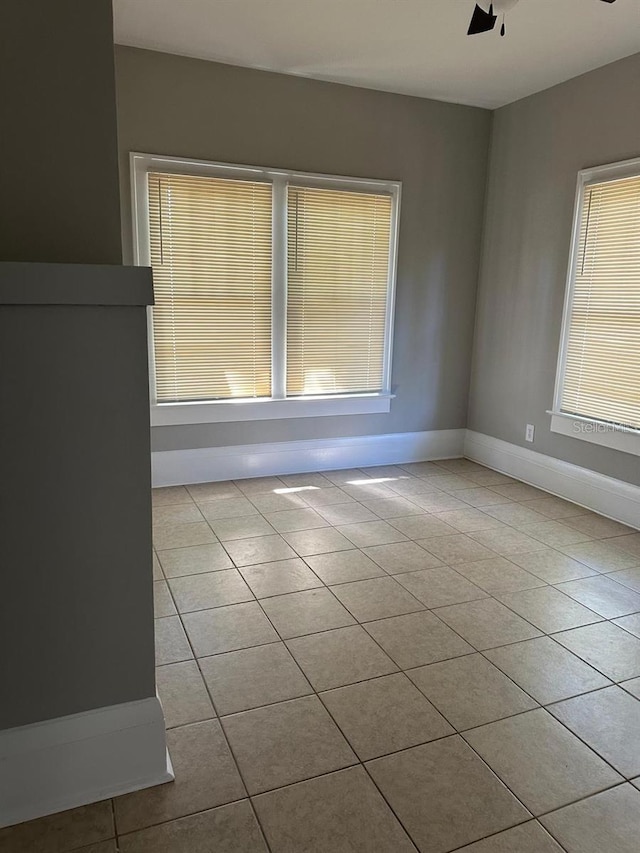 tiled spare room featuring ceiling fan