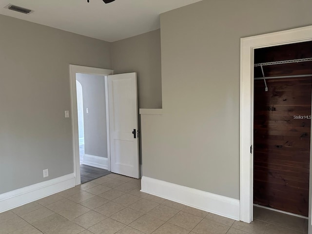 unfurnished bedroom featuring a spacious closet, a closet, and light tile patterned floors