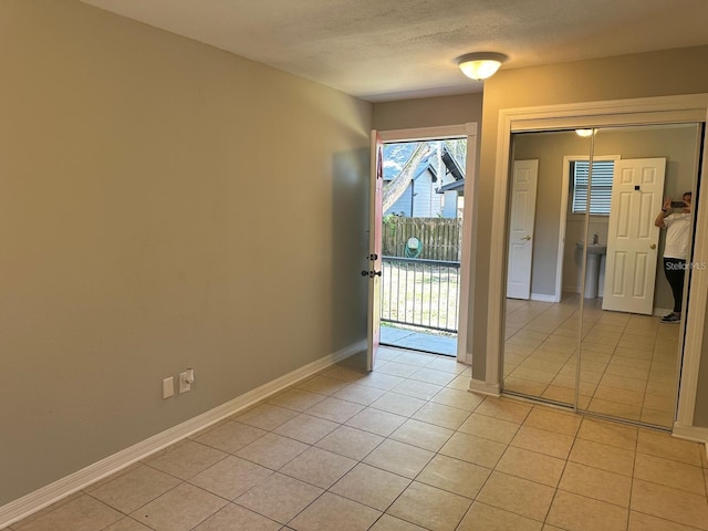 unfurnished room featuring light tile patterned floors and a textured ceiling