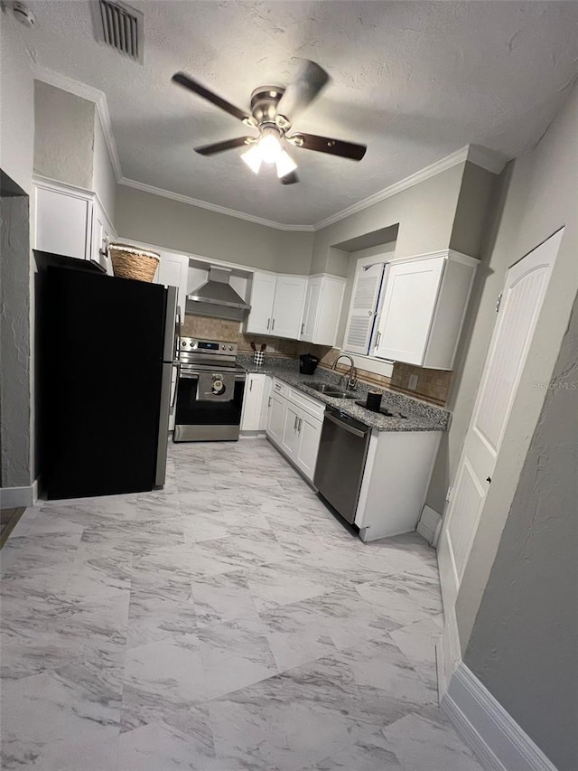 kitchen featuring white cabinetry, sink, stainless steel appliances, wall chimney range hood, and ornamental molding