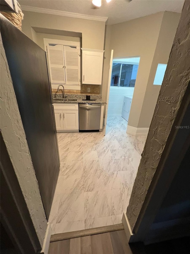 kitchen with white cabinets, light stone counters, crown molding, sink, and dishwasher