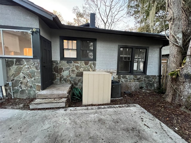 doorway to property featuring a patio area and central AC