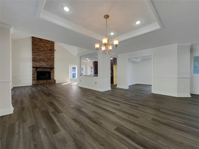 unfurnished living room with dark hardwood / wood-style floors, a fireplace, a raised ceiling, and a textured ceiling