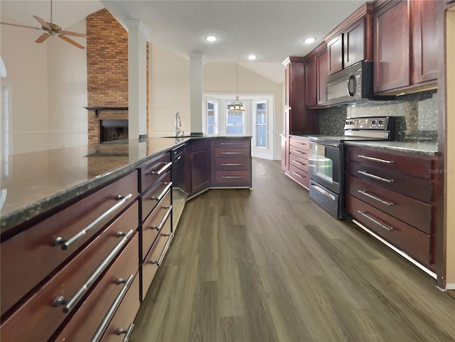 kitchen with pendant lighting, dark wood-type flooring, stainless steel electric stove, a large fireplace, and kitchen peninsula