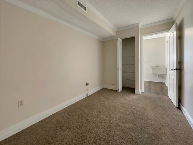 unfurnished bedroom with a textured ceiling, carpet floors, a closet, and ornamental molding