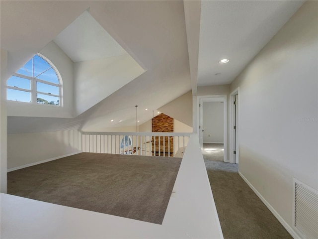 interior space with dark carpet and vaulted ceiling