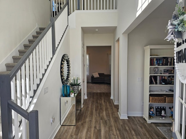 foyer entrance featuring a towering ceiling and dark hardwood / wood-style flooring