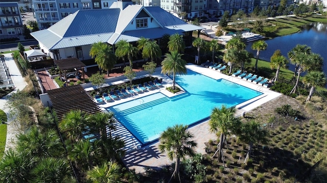 view of swimming pool with a patio area and a water view