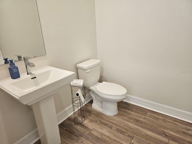 bathroom with hardwood / wood-style flooring and toilet