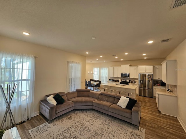 living room with plenty of natural light and dark hardwood / wood-style flooring