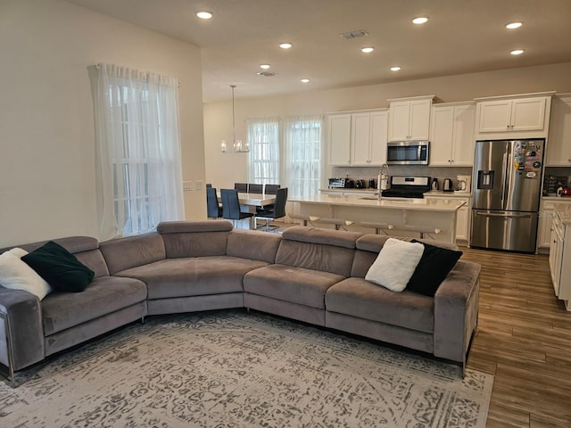 living room featuring dark wood-type flooring and an inviting chandelier