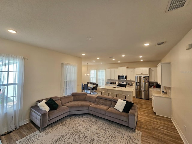 living room featuring sink, a healthy amount of sunlight, and hardwood / wood-style flooring