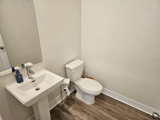 bathroom featuring sink, hardwood / wood-style floors, and toilet