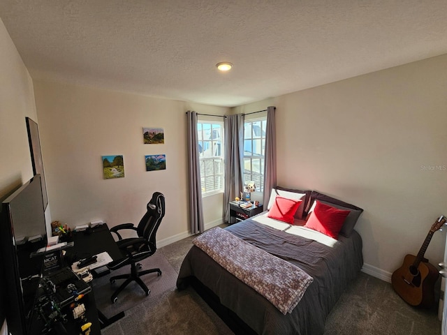 bedroom featuring a textured ceiling and dark carpet