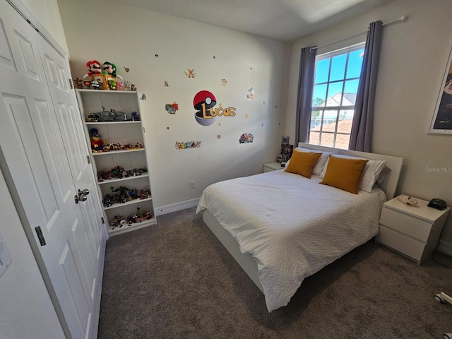 bedroom featuring dark colored carpet and a closet