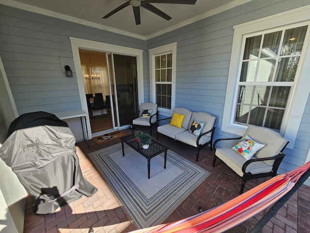 wooden deck featuring an outdoor living space, ceiling fan, and a patio