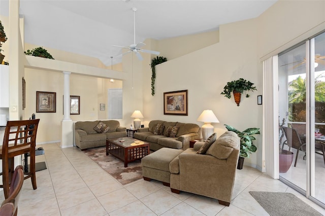 tiled living room featuring high vaulted ceiling, ornate columns, and ceiling fan