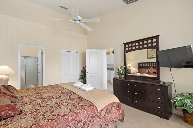 bedroom featuring light carpet, ensuite bath, ceiling fan, high vaulted ceiling, and a closet