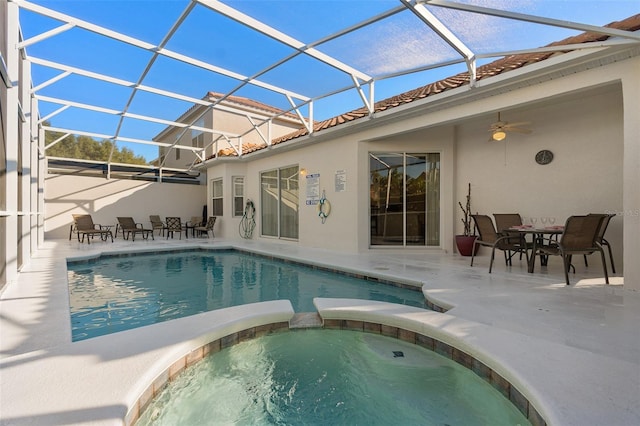 view of swimming pool featuring ceiling fan, a lanai, an in ground hot tub, and a patio