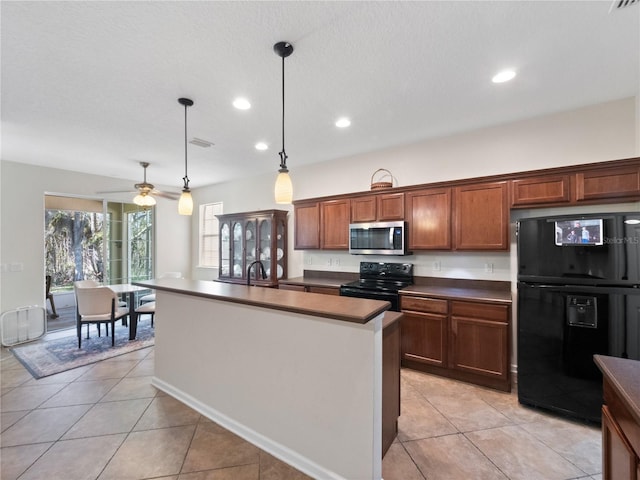 kitchen featuring ceiling fan, black appliances, pendant lighting, light tile patterned floors, and a center island with sink