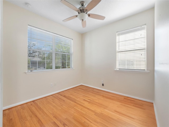 empty room with plenty of natural light, ceiling fan, and light wood-type flooring