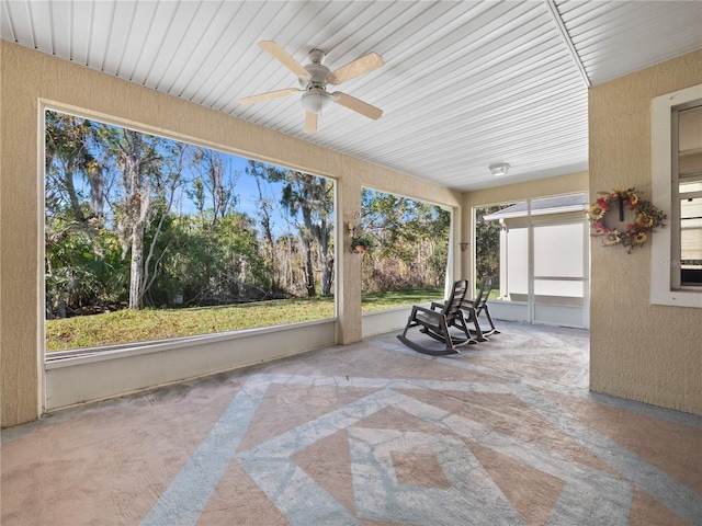 unfurnished sunroom featuring ceiling fan