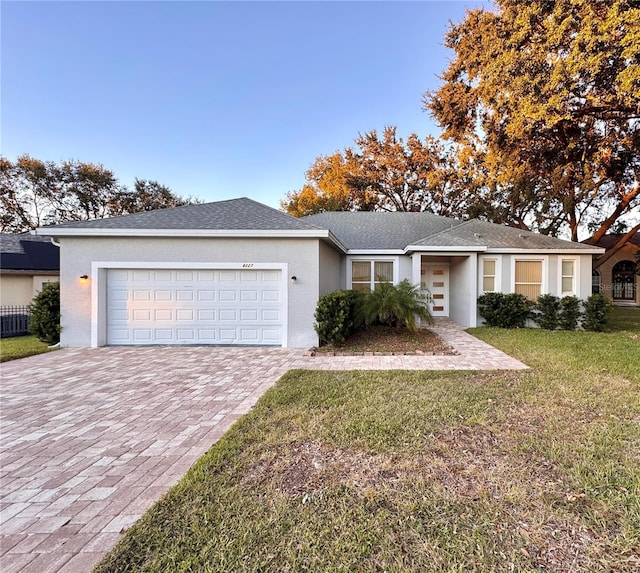 ranch-style home with a garage and a front lawn