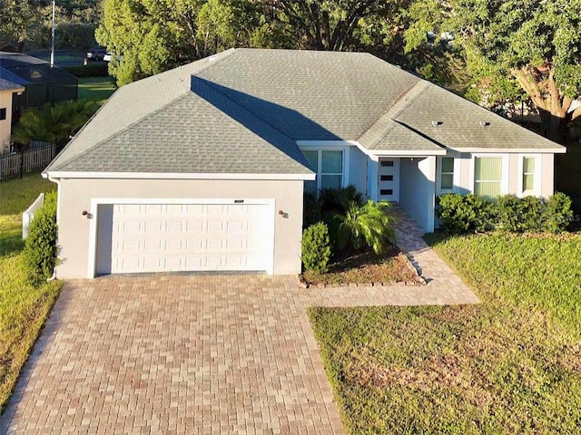 ranch-style home with a garage and a front lawn