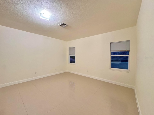 unfurnished room with a textured ceiling