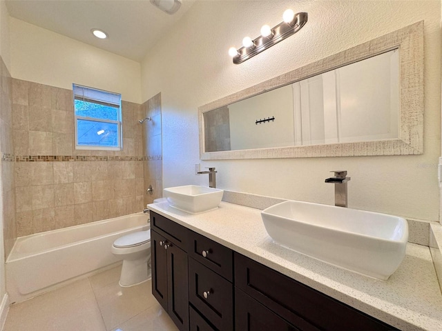 full bathroom with tile patterned flooring, vanity, tiled shower / bath combo, and toilet