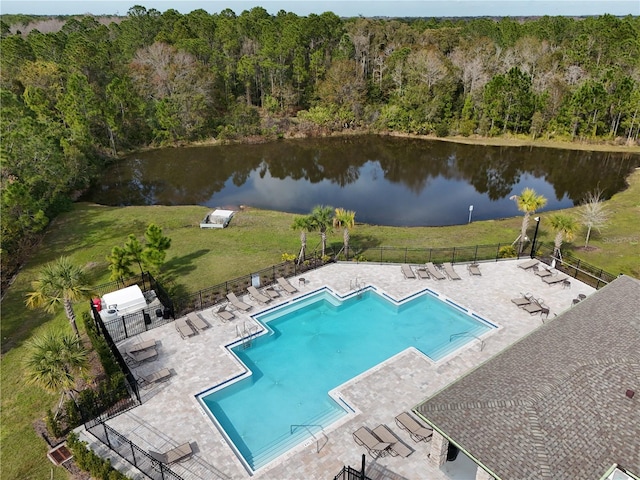 view of swimming pool with a patio area, a lawn, and a water view