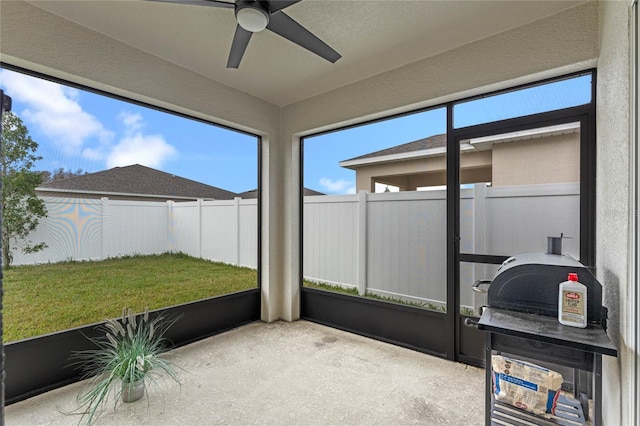 unfurnished sunroom with ceiling fan