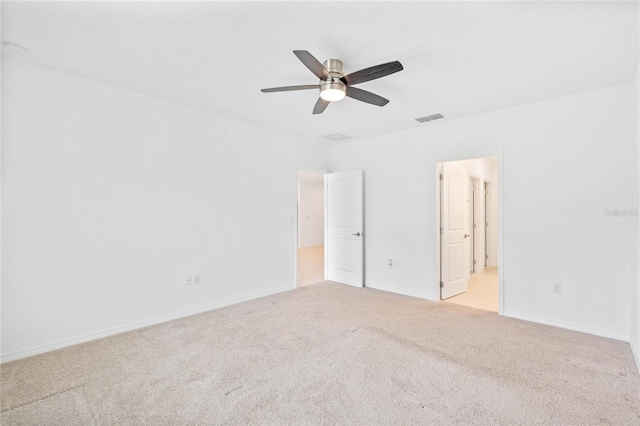 spare room featuring light carpet and ceiling fan