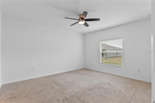 spare room with light colored carpet, a textured ceiling, and ceiling fan