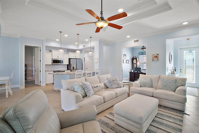 living room with light tile patterned floors, ceiling fan, and crown molding