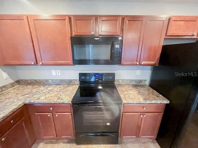 kitchen with light stone counters and black appliances