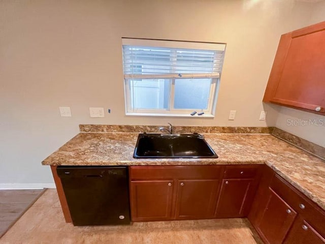 kitchen with light stone counters, sink, light hardwood / wood-style flooring, and black dishwasher