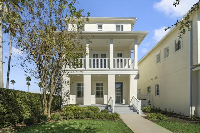 view of front facade featuring a balcony and a front lawn