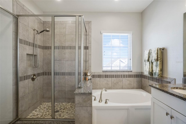 bathroom featuring plus walk in shower and vanity