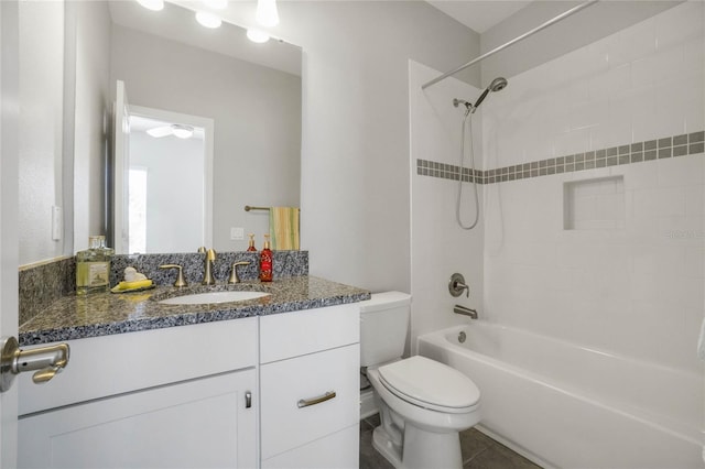 full bathroom featuring tile patterned floors, vanity, tiled shower / bath combo, and toilet