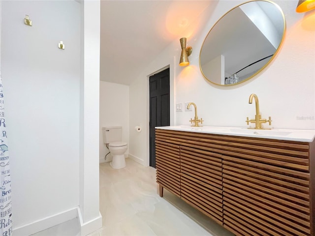 bathroom featuring vanity, toilet, and vaulted ceiling