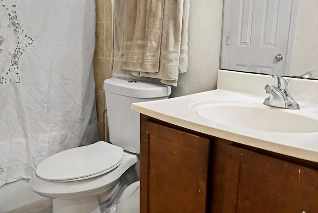 bathroom with a shower with shower curtain, vanity, and toilet