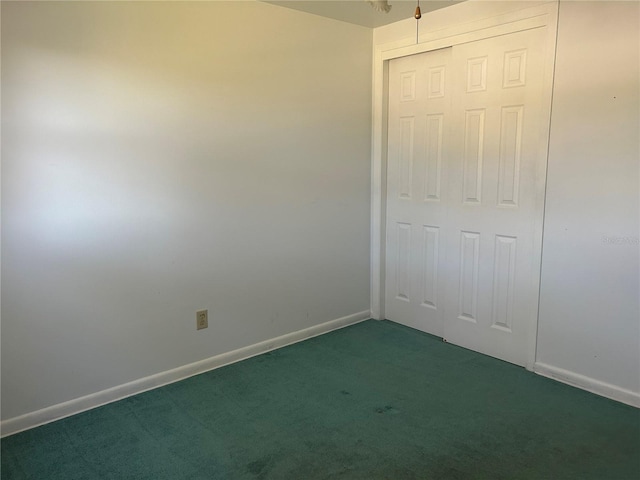 unfurnished bedroom featuring dark carpet and a closet