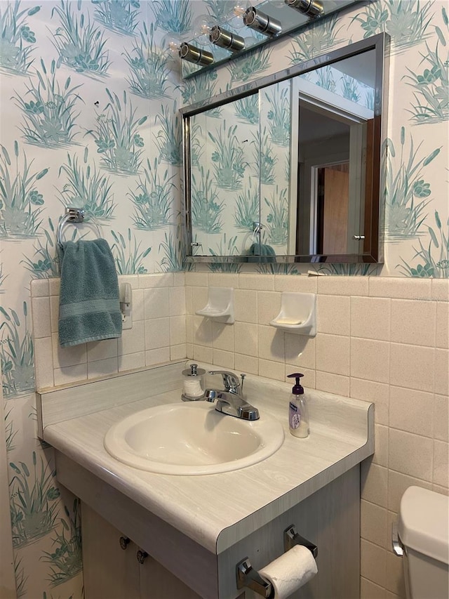 bathroom featuring tile walls, sink, and toilet