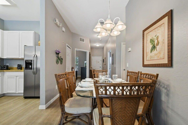 dining space with a notable chandelier and light wood-type flooring