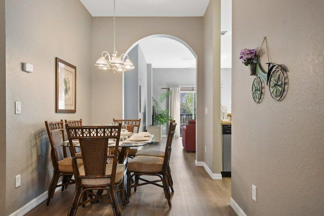 dining area with hardwood / wood-style floors and a chandelier