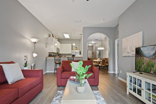 living room with light hardwood / wood-style floors and an inviting chandelier