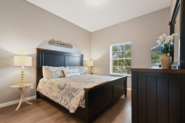 bedroom with dark hardwood / wood-style flooring and vaulted ceiling