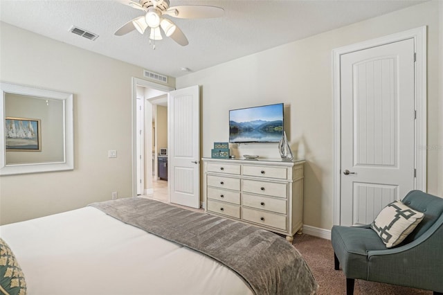 bedroom featuring ceiling fan, light colored carpet, and a textured ceiling