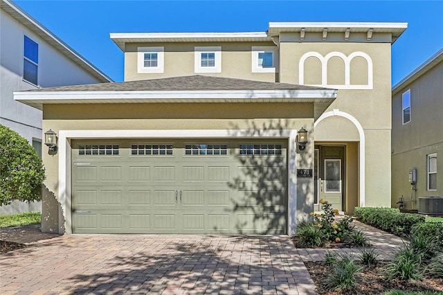 view of front of home featuring cooling unit and a garage